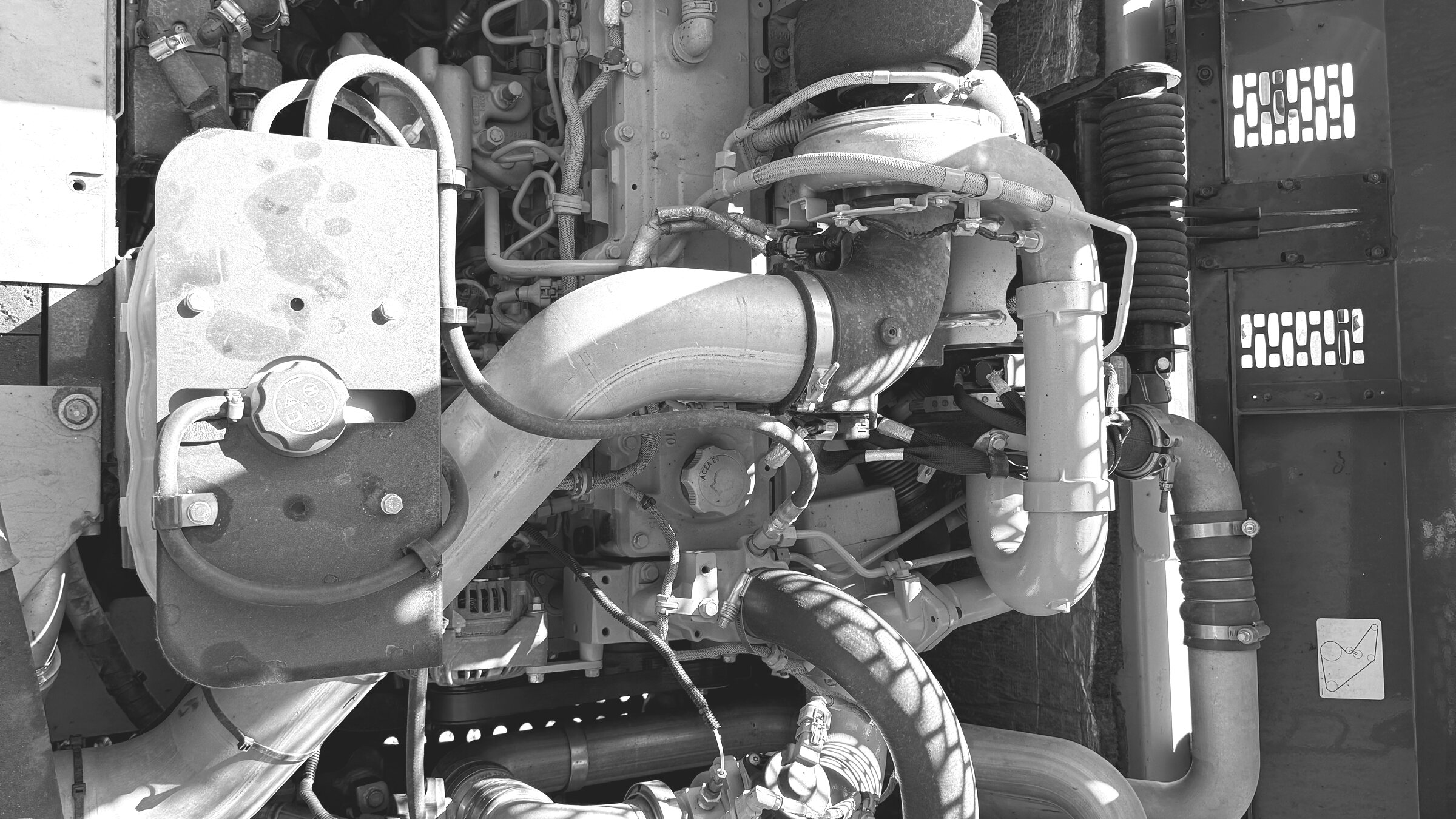 An open engine bay: the turbo, hoses and ducting of a working machine